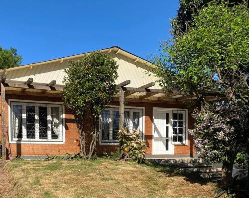 a small brick house with a tree in front of it at Casa bulgara boutique in Aristóbulo del Valle