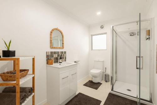 a bathroom with a shower and a sink and a toilet at Kauri Point Village in Tahawai