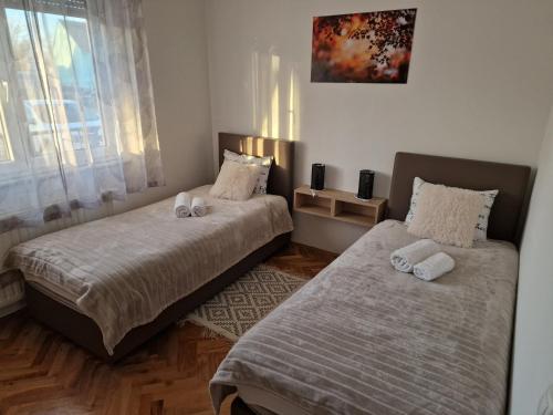 a bedroom with two beds with towels on them at Seasons apartmani in Osijek