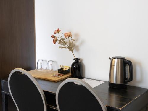 a table with two chairs and a vase with flowers at St Christopher's Inn Bruges - The Bauhaus in Bruges