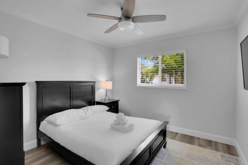 a bedroom with a bed and a ceiling fan at Delray Oasis Pool Hot Tub in Tropic Isle