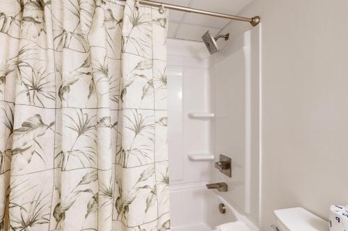a bathroom with a shower curtain with a plant pattern at Waikiki 406 in Ocean City