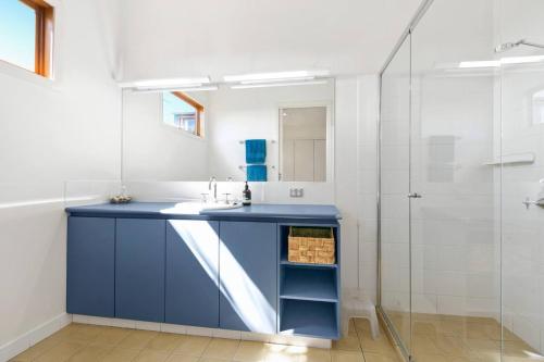 a bathroom with a blue sink and a shower at Sunrise By The Sea in Torquay