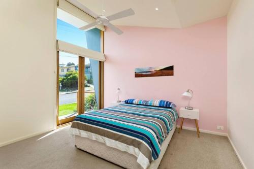 a bedroom with a bed and a window at Sunrise By The Sea in Torquay