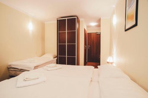 a hotel room with two beds and a closet at Hotel Trojan in Lądek-Zdrój