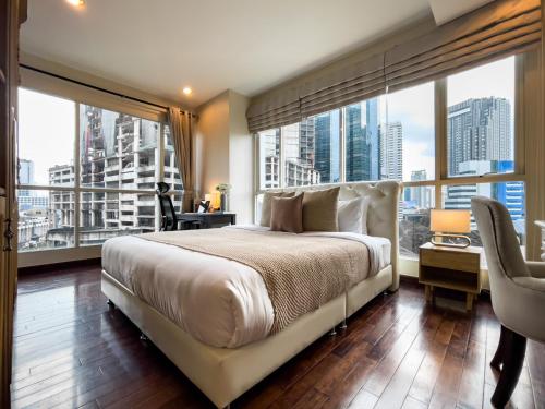 Un dormitorio con una cama grande y una ventana grande en 300m BTS l Large 110 sqm l Pool and Sauna, en Makkasan