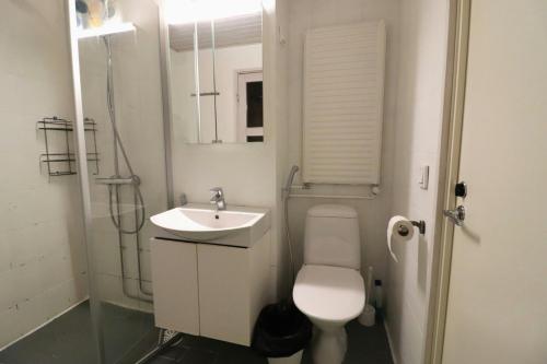 a white bathroom with a toilet and a sink at Central and Spacious Apartment for 4 with Sauna in Kirkkonummi