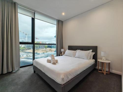 a bedroom with a large bed and a large window at Brand new 2BR APT in Castle Hill in Castle Hill