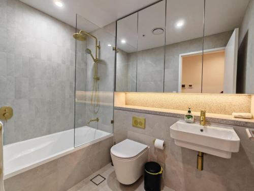 a bathroom with a toilet and a sink and a tub at Brand new 2BR APT in Castle Hill in Castle Hill