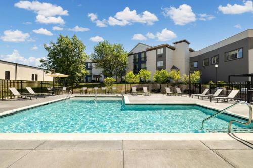 a swimming pool with chairs and a building at Residence Inn by Marriott King of Prussia in King of Prussia