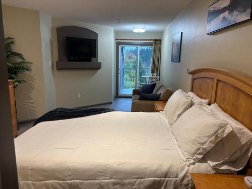 a bedroom with a large white bed and a couch at Oceanside Getaway in Nanoose Bay