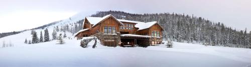 a log cabin in the snow in front at Blue Moon Challet in Big Sky Mountain Village