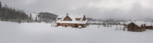 a house is covered in snow in front at Blue Moon Challet in Big Sky Mountain Village