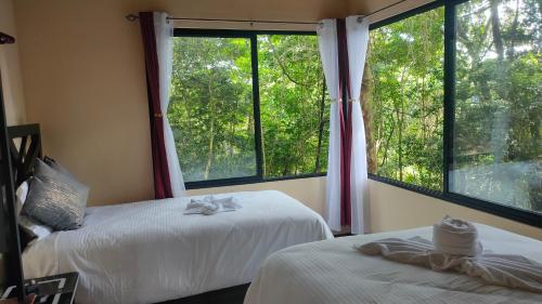 a bedroom with two beds and a large window at Monteverde Beaumont in La Cruz