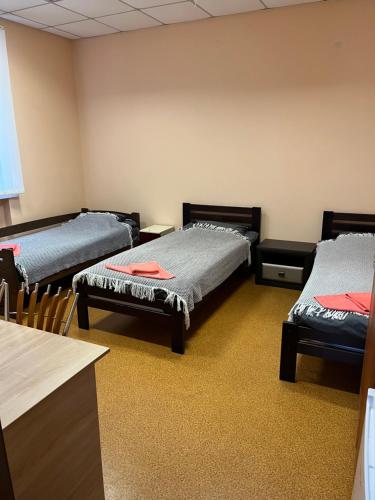 a room with three beds in a room at Seven Hotel VIP in Korostenʼ