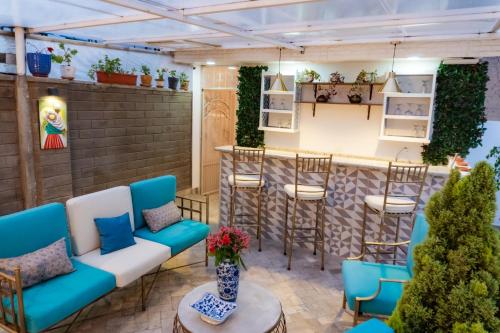 a patio with blue chairs and a bar at Adamas House Hotel Boutique in Quito