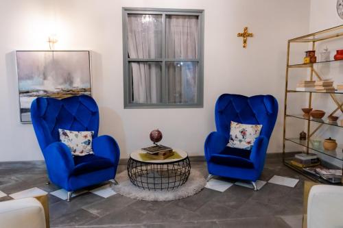 two blue chairs and a table in a room at Adamas House Hotel Boutique in Quito