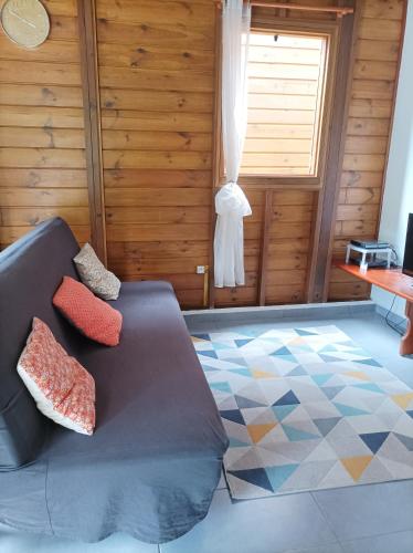 a living room with a couch and a window at Gîte Ti Roucou in Petit-Bourg