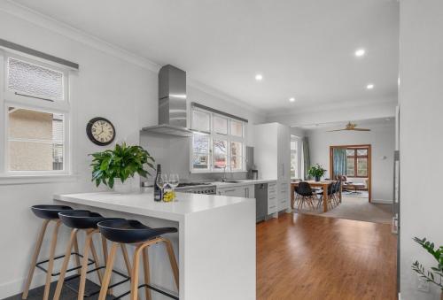 a kitchen with a white counter and bar stools at Clyde on Sunderland in Clyde