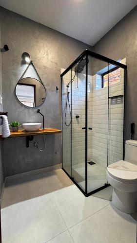 a bathroom with a glass shower and a sink at Chalés da Bica - Modernidade e Aconchego a 100m da Praia in Paracuru