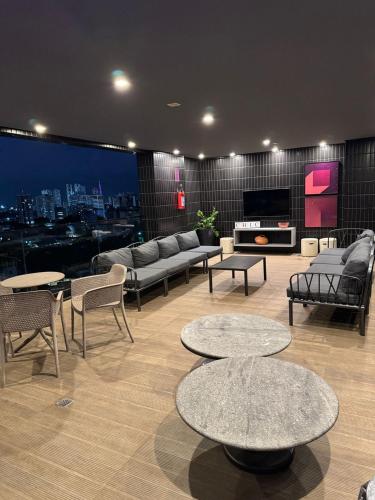 a living room with tables and couches and a city at Tolive One - Leite Island, Recife in Recife