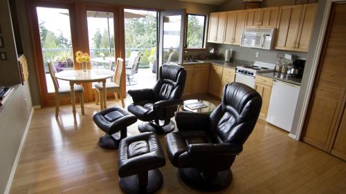 a kitchen with black leather chairs and a table at Olympic View Cottage in Gregory Heights