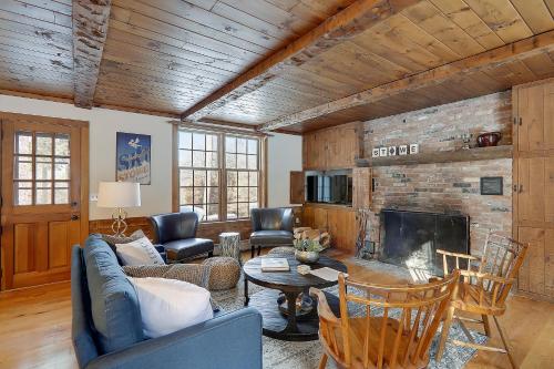 Una sala de estar con un sofá y una chimenea. en Two Chimneys: 5 br, a/c, fireplace, deck & hot tub, firepit, garage!, en Stowe