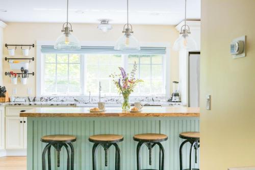 a kitchen with green cabinets and a counter with stools at VERt MONsTre in Stowe