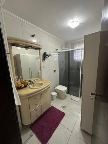 a bathroom with a sink and a shower and a toilet at Vista ao mar no Gonzaga in Santos