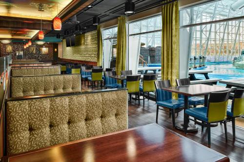 a restaurant with a pool and tables and chairs at Residence Inn by Marriott Rapid City in Rapid City