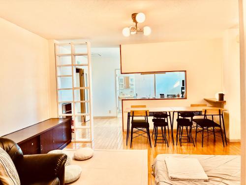 a living room with a dining room table and chairs at バス停"平城札所前"徒歩0分 四国愛媛の宿 "40番たっきゅうミニホテル" "No40 Takkyu mini hotel" in Hirajō