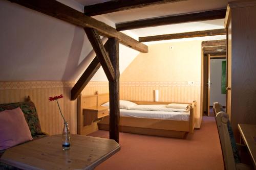 Un dormitorio con una cama y una mesa con un jarrón. en Hotel Garni Promenade, en Weissenhorn