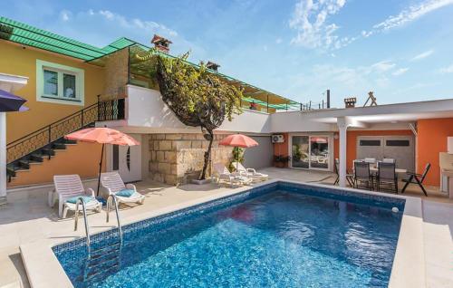 a swimming pool with chairs and a house at Cozy Home In Tinjan in Tinjan