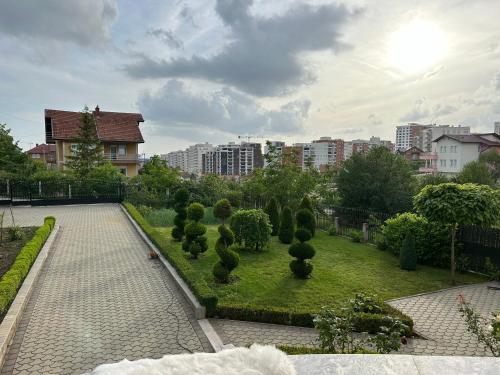 a garden with bushes and trees in a city at Modern house near Center in Prishtinë