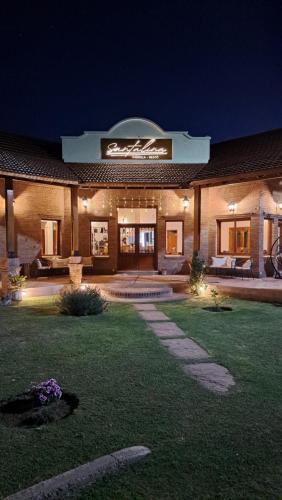 a large building with a lawn in front of it at night at Ayres del Golf Posada-Restó in Merlo