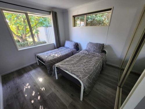 Ένα ή περισσότερα κρεβάτια σε δωμάτιο στο 2 bedroom whole house 1 Queen 2 Single bed