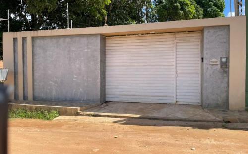 la puerta del garaje de un edificio con un camino de tierra en Charcara JJC, en Arapiraca