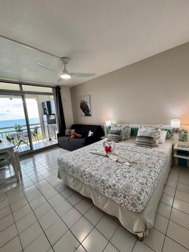 a bedroom with a large bed with a view of the ocean at Le Blue Ground Vue Mer in Le Diamant
