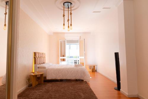 een witte slaapkamer met een bed en een raam bij Iconic 2 Bedroom Apartment in Tanger