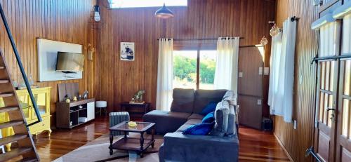ein Wohnzimmer mit Sofa und Tisch in der Unterkunft Rancho Bela Vista - o seu recanto em Pelotas in Pelotas
