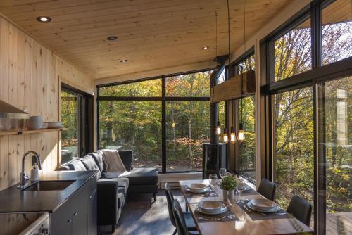 a kitchen and living room in a tree house at Montagne le Maelström in Lac-Beauport