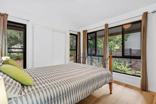 レインボー・ビーチにある43 Satinwood Drive Rainbow Shoresのベッドと大きな窓のある寝室