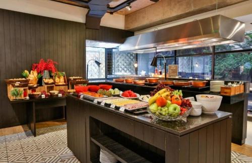 a kitchen with a buffet with fruits and vegetables on it at CONFORT iNN JARDINS in São Paulo