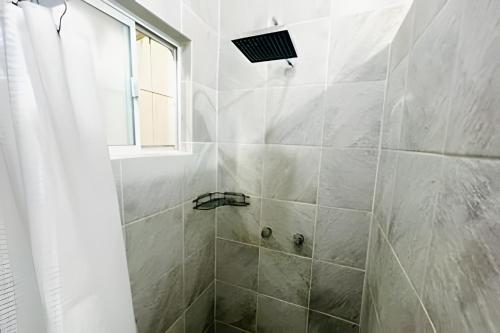 a bathroom with a shower with a window at 02-Hermoso apt en el centro de mty in Monterrey