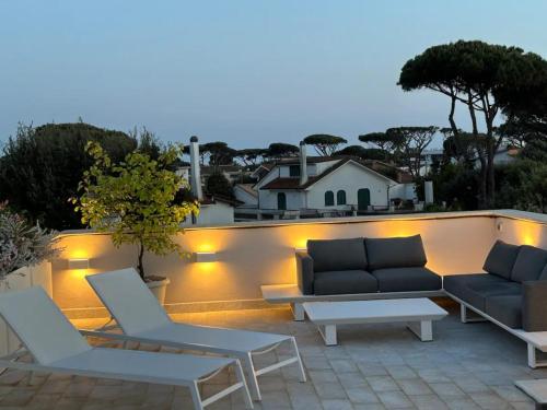 a patio with couches and tables on a roof at Fregene Tiny house close to the sea in Fregene