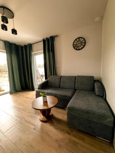 a living room with a couch and a table at Apartamenty Brzozowe in Okoniny Nadjezierne