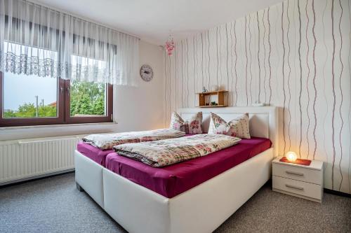 a bedroom with a white bed with purple sheets at Ferienwohnung auf der Insel Rügen in Bergen auf Rügen