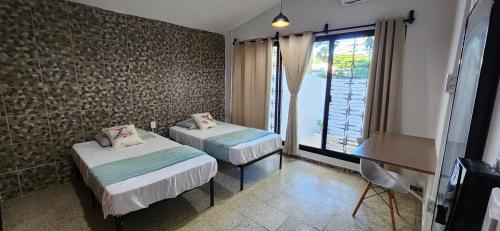 une chambre avec deux lits et une fenêtre dans l'établissement Loft Colibrí, à Ciudad del Carmen