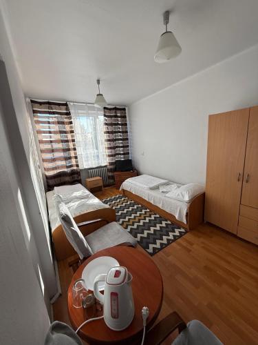 a room with two beds and a table in it at Noclegi Maria in Chełm