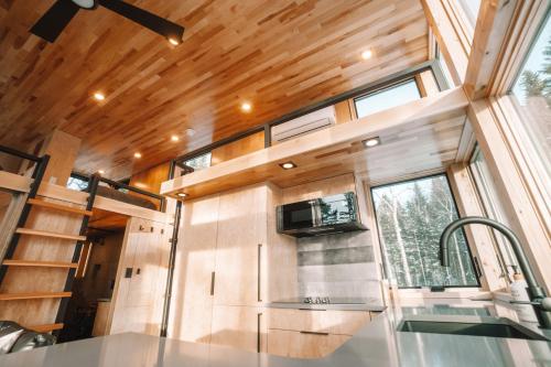 a kitchen in a tiny house with a window at Montagne le Maelström in Lac-Beauport